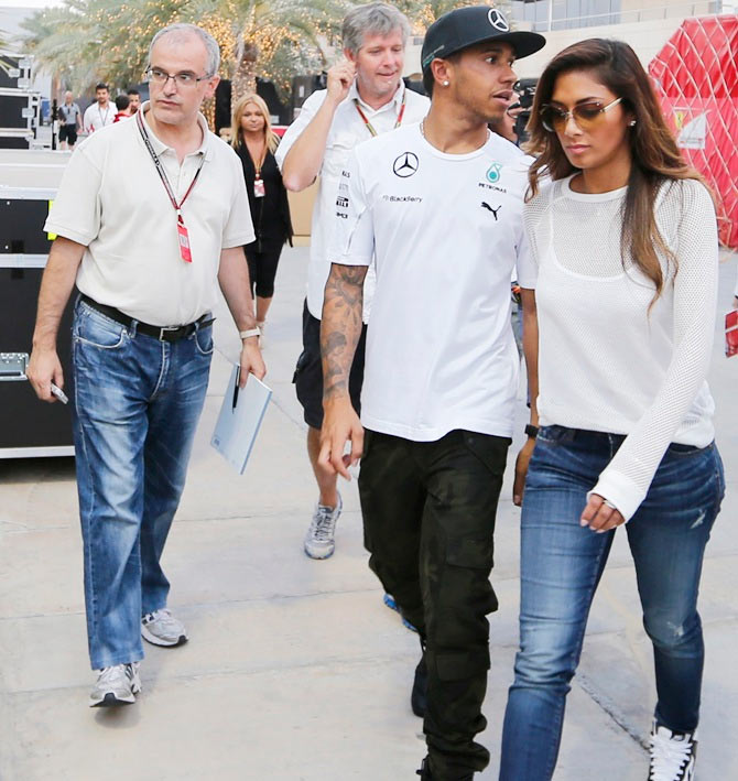 Mercedes Formula One driver Lewis Hamilton of Britain walks with his girlfriend Nicole Scherzinger