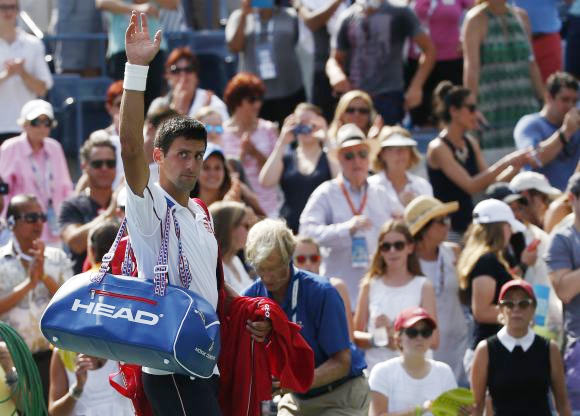 Novak Djokovic of Serbia waves to the crowd as he departs after being defeated by Kei Nishikori of Japan 