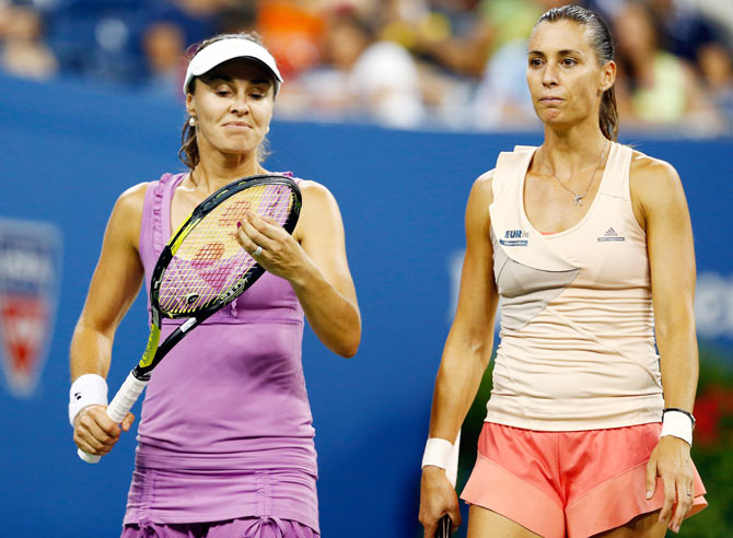 Martina Hingis (left) of Switzerland and Flavia Pennetta (right) of Italy react to a point against Ekaterina Makarova and Elena Vesnina of Russia