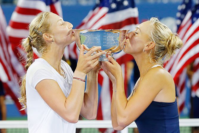 Ekaterina Makarova (left) and Elena Vesnina (right) of Russia kiss the trophy after defeating Martina Hingis of Switzerland and Flavia Pennetta of Italy in their US Open women's doubles final on Saturday