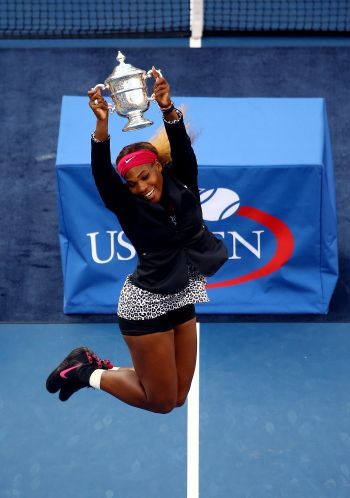 Serena Williams celebrates with the trophy after defeating Caroline Wozniacki to win their women's singles final match of the 2014 US Open title
