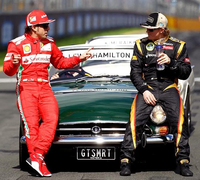 Fernando Alonso (left) speaks to Kimi Raikkonen