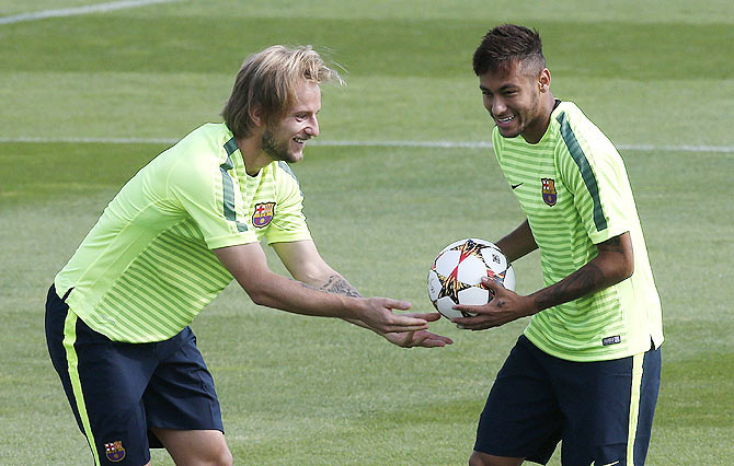 Barcelona's Neymar (right) jokes with teammate Ivan Rakitic during their training session