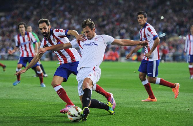 Grzegorz Krychowiak of Sevilla FC holds back Juanfran of Club Atletico de Madrid during the La Liga match between Club Atletico de Madrid and Sevilla FC