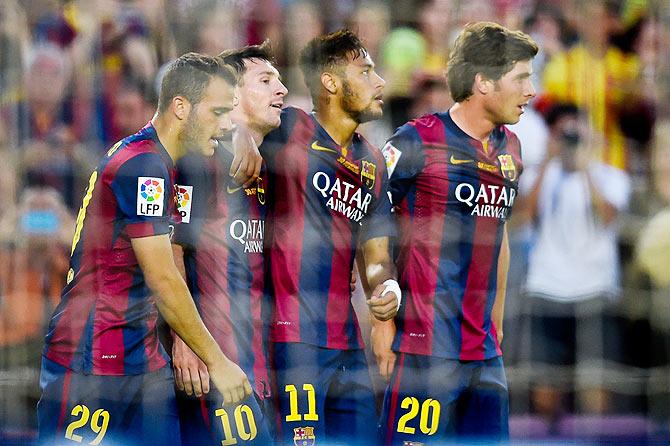 Lionel Messi (2ndL) of FC Barcelona celebrates with his teammates (L-R) Sandro, Neymar and Sergio Roberto of FC Barcelona after scoring his team's sixth goal during the La Liga match between FC Barcelona and Granada CF 