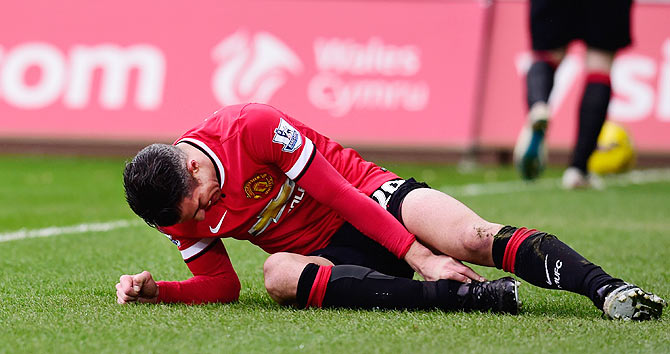 Manchester United's Robin Van Persie lies injured during the English Premier League match against Swansea City at Liberty Stadium in Swansea, Wales, on February 21