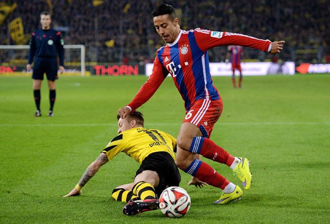 Thiago Alcantara (right) of Bayern Munich is challenged by Marco Reus (left) of Dortmund during their Bundesliga match at Signal Iduna Park in Dortmund on Saturday