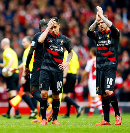  Liverpool's Philippe Coutinho shows his dejection as teammate Alberto Moreno applauds the fans after their Premier League match against Arsenal at Emirates Stadium on Saturday