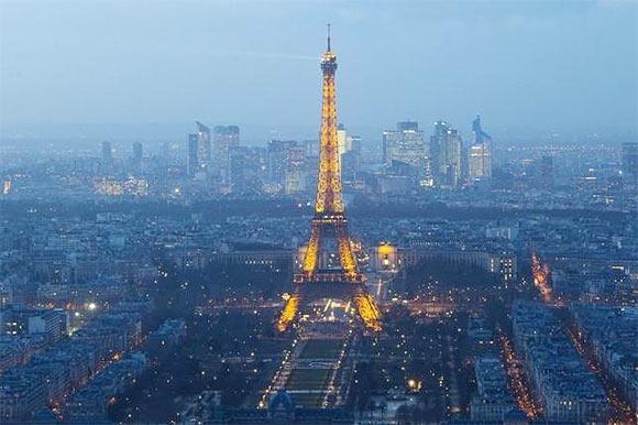  A view shows the illuminated Eiffel Tower and La Defense business district (background) in Paris February 24, 2015