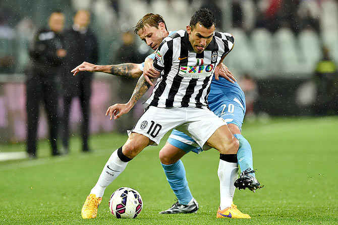 Juventus' Carlos Tevez (right) is challenged by SS Lazio's Lucas Biglia during their Serie A match at Juventus Arena in Turin on Saturday