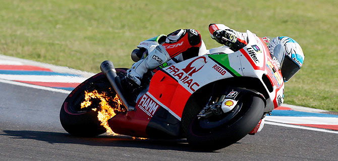 Pramac Ducati Racing rider Yonny Hernandez of Colombia rides his motorcycle as fire is seen on it during Argentina's MotoGP Grand Prix at the Termas de Rio Hondo International circuit 