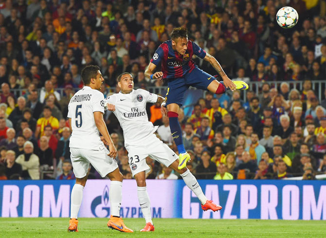 Barcelona's Neymar outjumps PSG's Marquinhos (5) and Gregory van der Wiel (23) to head a goal