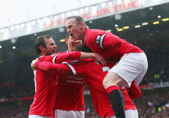 Marouane Fellaini of Manchester United (2R) is congratulated by captain Wayne Rooney (R) and teammates 