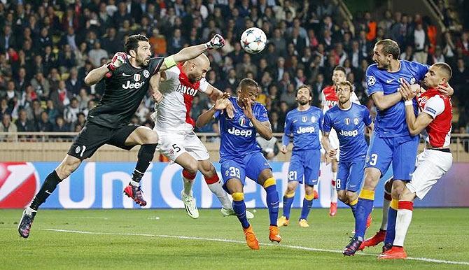 Juventus goalkeeper Gianluigi Buffon (left) and his teammate Patrice Evra (centre) challenge Monaco's Aymen Abdennour (2nd from left)