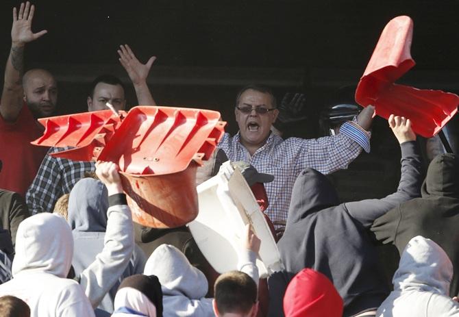 Nebojsa Covic,centre, vice President of Red Star Belgrade, tries to stop fans during clashes with riot police