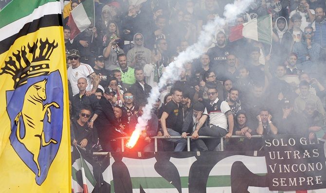 Juventus' supporters look on as a flare is thrown 
