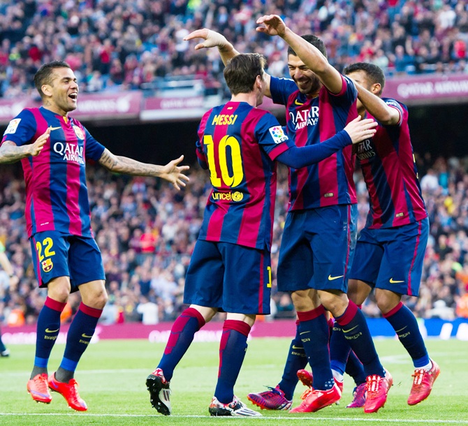 Dani Alves,left, Rafinha, right, and Lionel Messi, centre, celebrate 