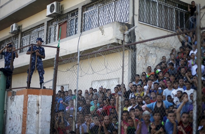 Palestinian spectators are pictured through a fence