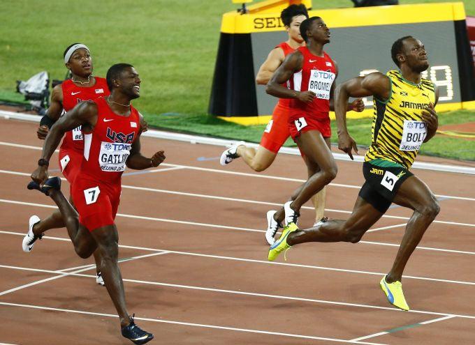 Usain Bolt of Jamaica (R) looks at the scoreboard after the men's 100 metres final at the 15th IAAF World Championships at the National Stadium in Beijing