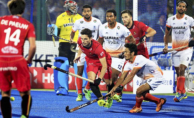 Players of India and Belgium (in red jersey) in action during the second semi-final of the Hockey World League in Raipur on Saturday