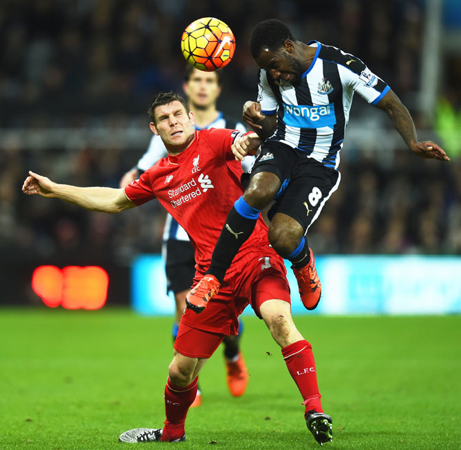 Newcastle's Vurnon Anita (right) wins an aeriel ball as he is challenged by Liverpool's James Milner
