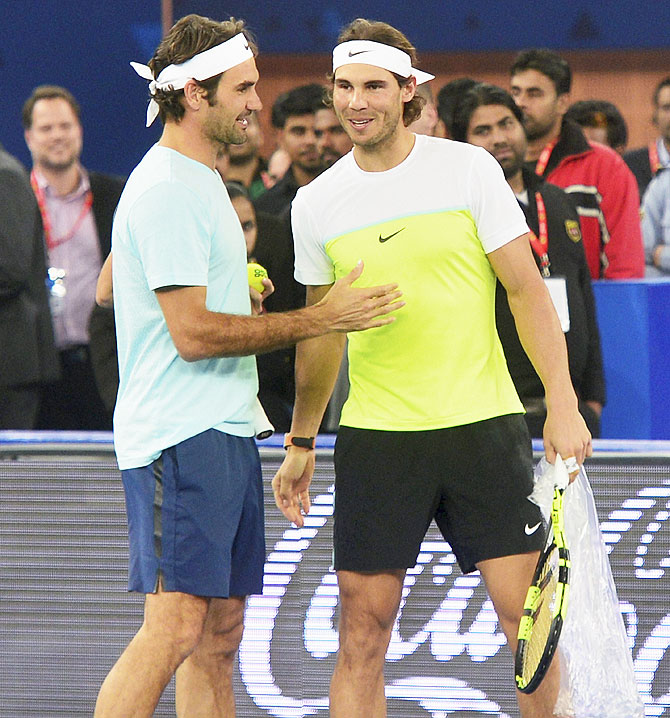 Indian Aces' Rafael Nadal (right) and UAE Royals' Roger Federer greet each other before their International Premier Tennis League (IPTL) set at IG Stadium in New Delhi