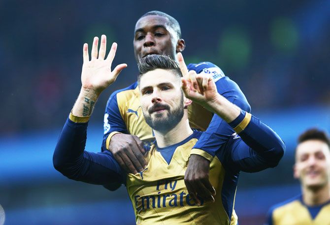 Olivier Giroud of Arsenal celebrates with Joel Campbell as he scores their first goal from a penalty during the Barclays Premier League match against Aston Villa