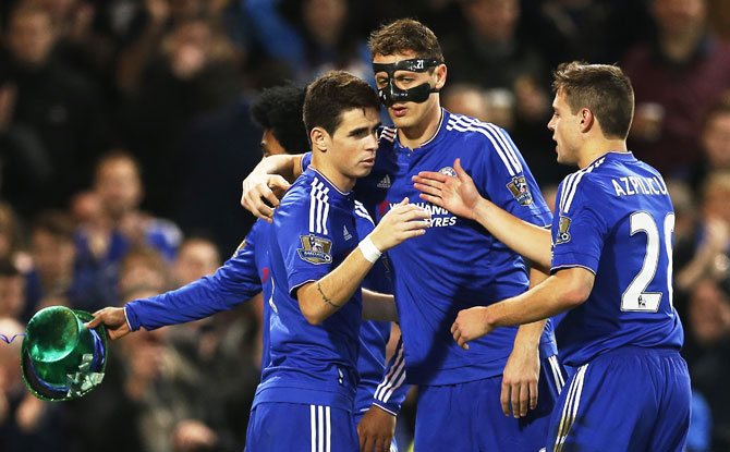 Chelsea's Oscar celebrates with teammates after scoring the third goal from the penalty spot during their English Premier League match at Stamford Bridge in London on Saturay