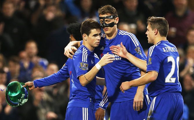 Chelsea's Oscar celebrates with teammates after scoring the third goal from the penalty spot during their English Premier League match at Stamford Bridge in London on Saturay
