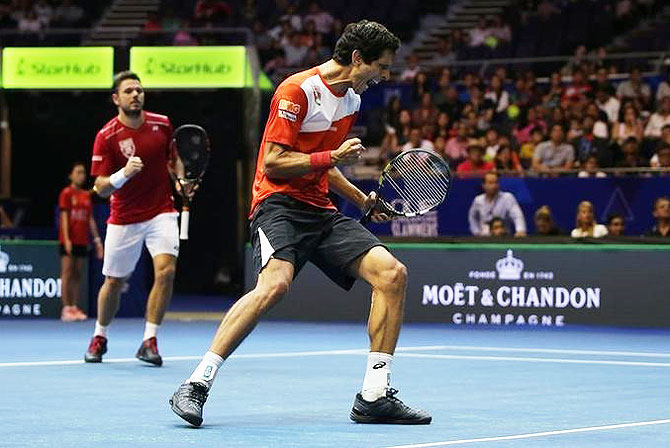 Singapore Slammers' Marcelo Melo celebrates as Stan Wawrinka looks on