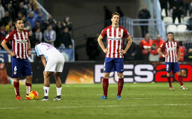 Fernando Torres and Filipe Luis react after Malaga's goal 