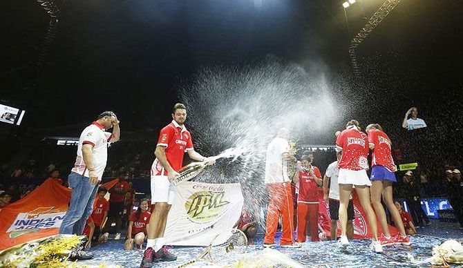 Stan Wawrinka sprays champagne with members of the Singapore Slammers after beating Indian Aces to win the Indian Premier Tennis League 2 final