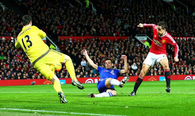 Chelsea's Thibaut Courtois saves an effort from Manchester United's Ander Herrera as Chelsea's Cesar Azpilicueta slides in