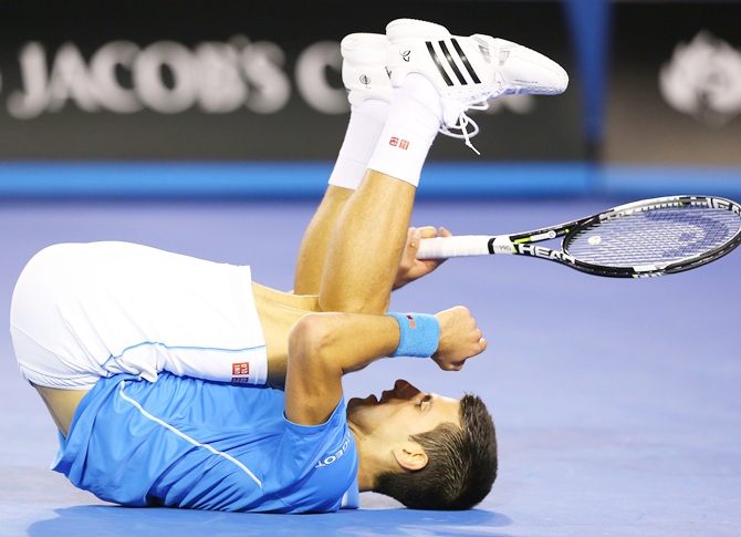 Novak Djokovic of Serbia falls to the court