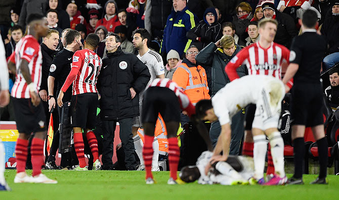 Ryan Bertrand of Southampton argues with the Swansea bench after his foul on Modou Barrow (lying on the pitch)
