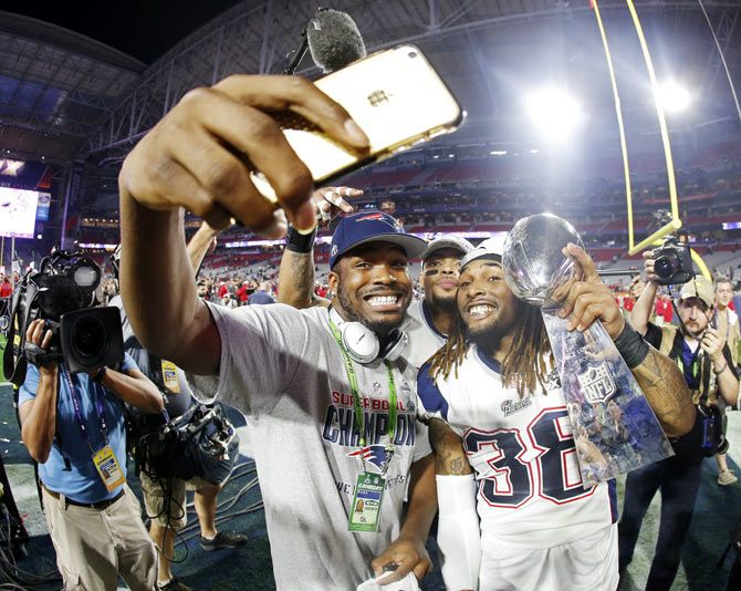 Members of the New England Patriots click a selfie as they celebrate with the Vince Lombardi Trophy after defeating the Seattle Seahawks in Super Bowl XLIX