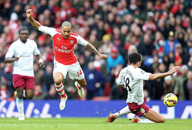 Theo Walcott of Arsenal (left) is tackled by Kieran Richardson of Aston Villa