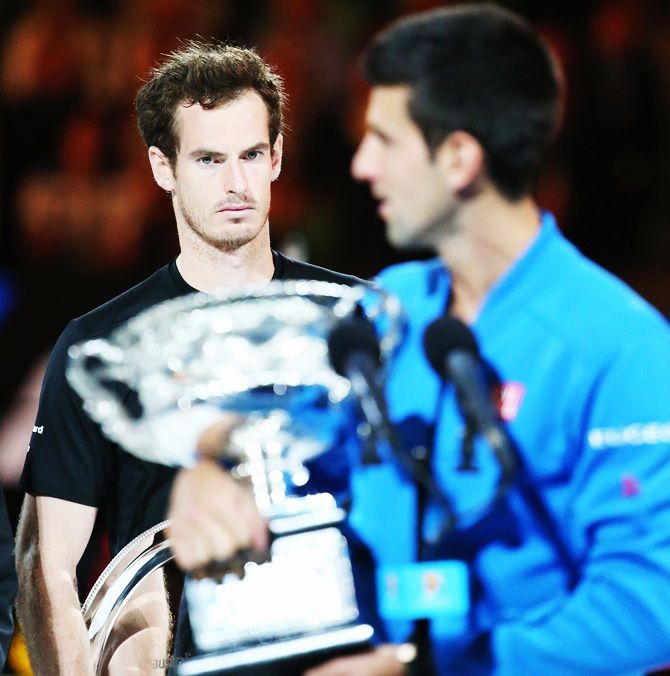 Andy Murray of Great Britain looks on as Novak Djokovic of Serbia holds the Norman Brookes Challenge Cup