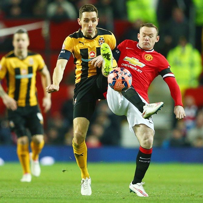 Tom Champion of Cambridge United and Wayne Rooney of Manchester United