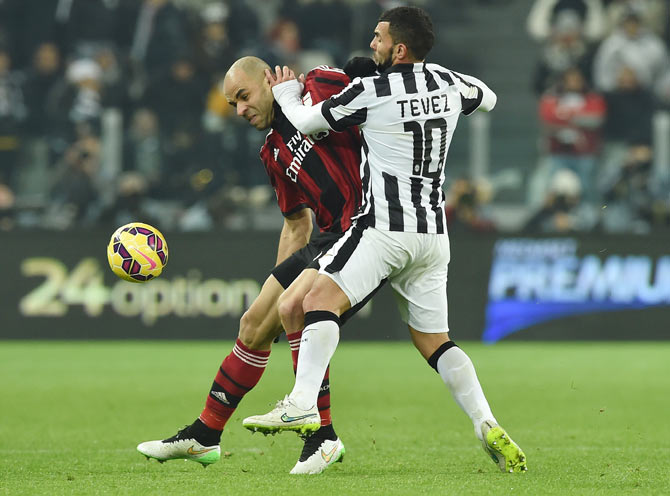 Carlos Tevez (right) of Juventus FC challenges Alex Dias Da Costa of AC Milan during their Serie A match at Juventus Arena in Turin on Saturday