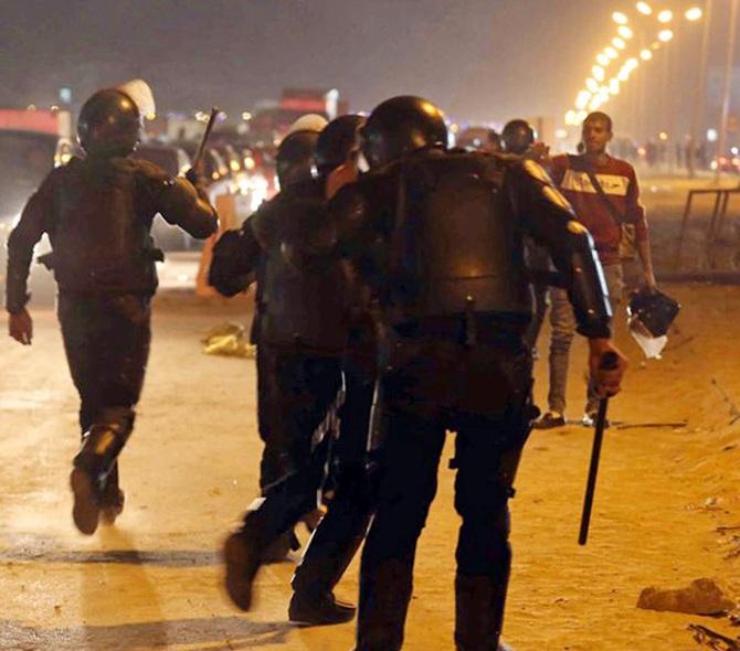 Policemen and soccer fans argue during a scuffle as fans attempt to enter a   stadium to watch a match