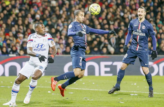Olympique Lyon's Henri Bedimo (left) challenges Lucas (centre) of Paris St Germain during their French Ligue 1 match at the Gerland stadium in Lyon on Sunday