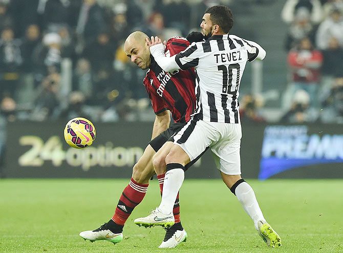 Carlos Tevez (right) of Juventus FC challenges Alex Dias Da Costa of AC Milan during their Serie A match at Juventus Arena in Turin on Saturday