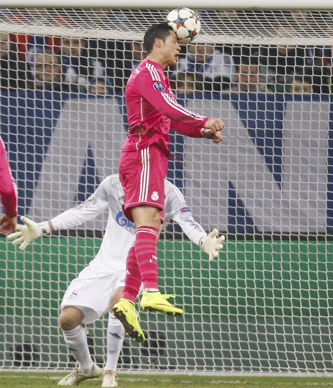 Real Madrid's Cristiano Ronaldo (top) scores a goal past Schalke 04's goalkeeper Timon Wellenreuther
