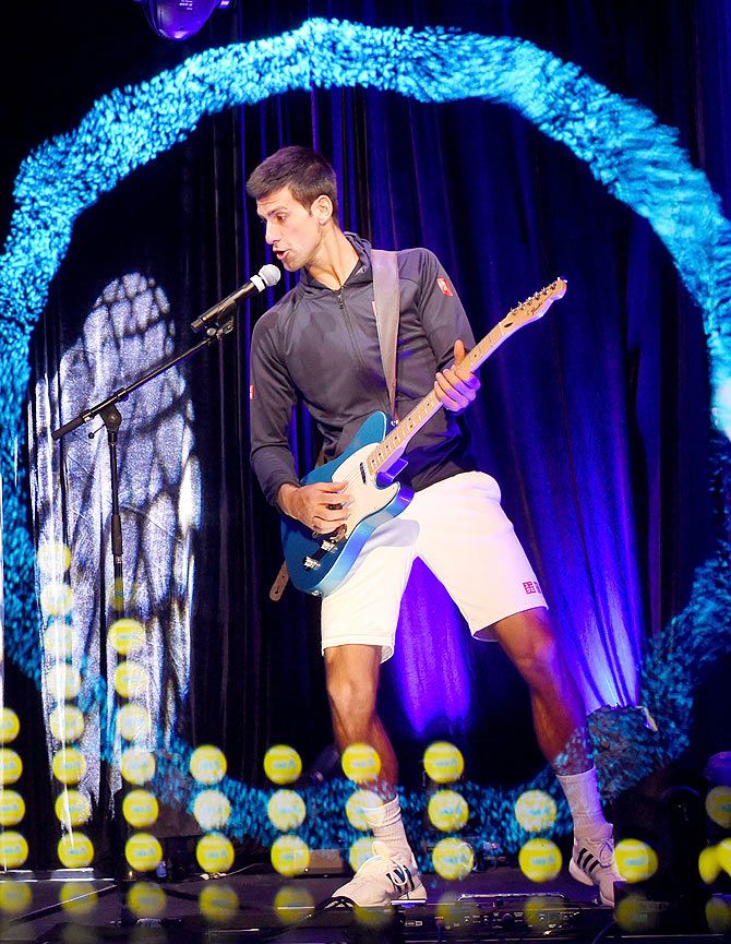 Novak Djokovic plays guitar at the ANZ Jam Slam on Grand Slam Oval with a hologram of Aussie music star Keith Urban during the 2015 Australian Open at Melbourne Park in Melbourne on January 25, 2015