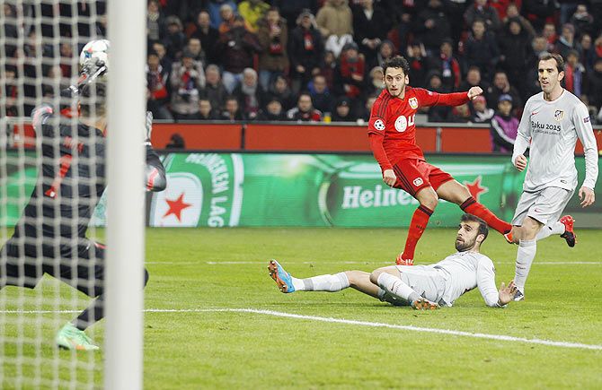 Bayer Leverkusen's Hakan Calhanoglu (centre) scores a goal past Atletico Madrid's goalkeeper Miguel Angel Moya (left) during their Champions League round of 16, first leg match in Leverkusen on Wednesday