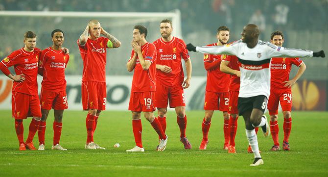 Liverpool players look dejected as Demba Ba of Besiktas (9) celebrates after Dejan Lovren of Liverpool misses the decisive kick in the penalty shootout