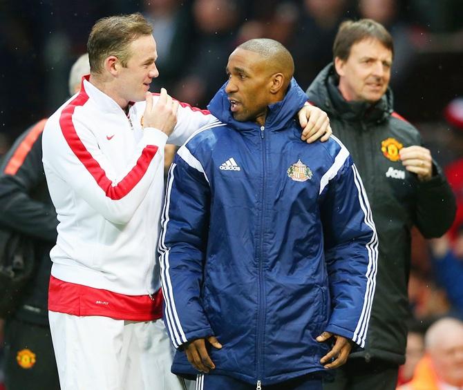 Wayne Rooney of Manchester United chats Jermain Defoe of Sunderland