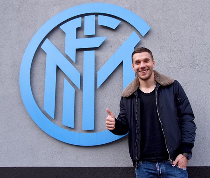 Lukas Podolski poses for a photo in front FC Internazionale's logo