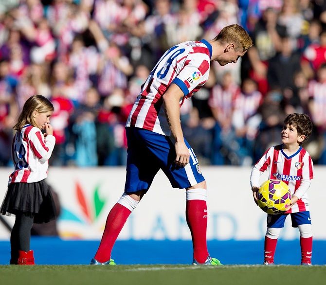 Football player Fernando Torres speaks with his kids during his presentation as new Club Atletico de Madrid signing